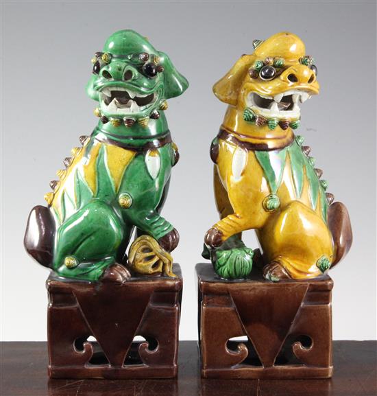 A pair of Chinese sancai glazed figures of Buddhist lions seated on plinths, 19th/20th century, 25cm